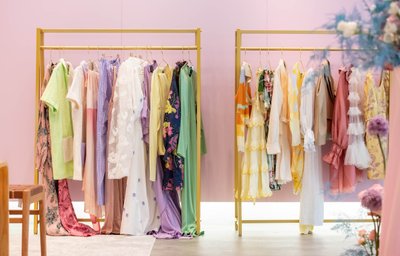 Colourful dresses against a pink wall