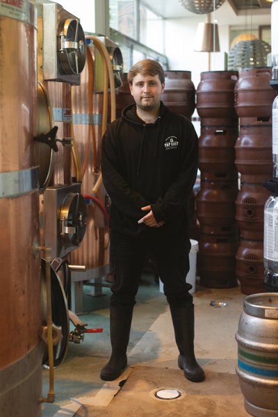 Man standing brewing equipment