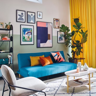Blue sofa living room colourful artwork walls