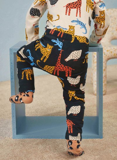 A child wearing a Lindex top, leggings and socks