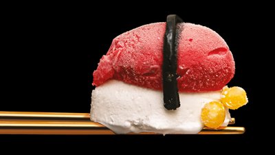 Ice cream sushi balanced on gold chopsticks