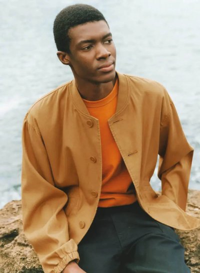 A man wearing a Uniqlo U unisex bomber and unisex t-shirt