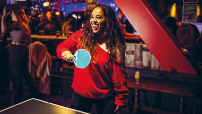Woman red jumper playing ping pong